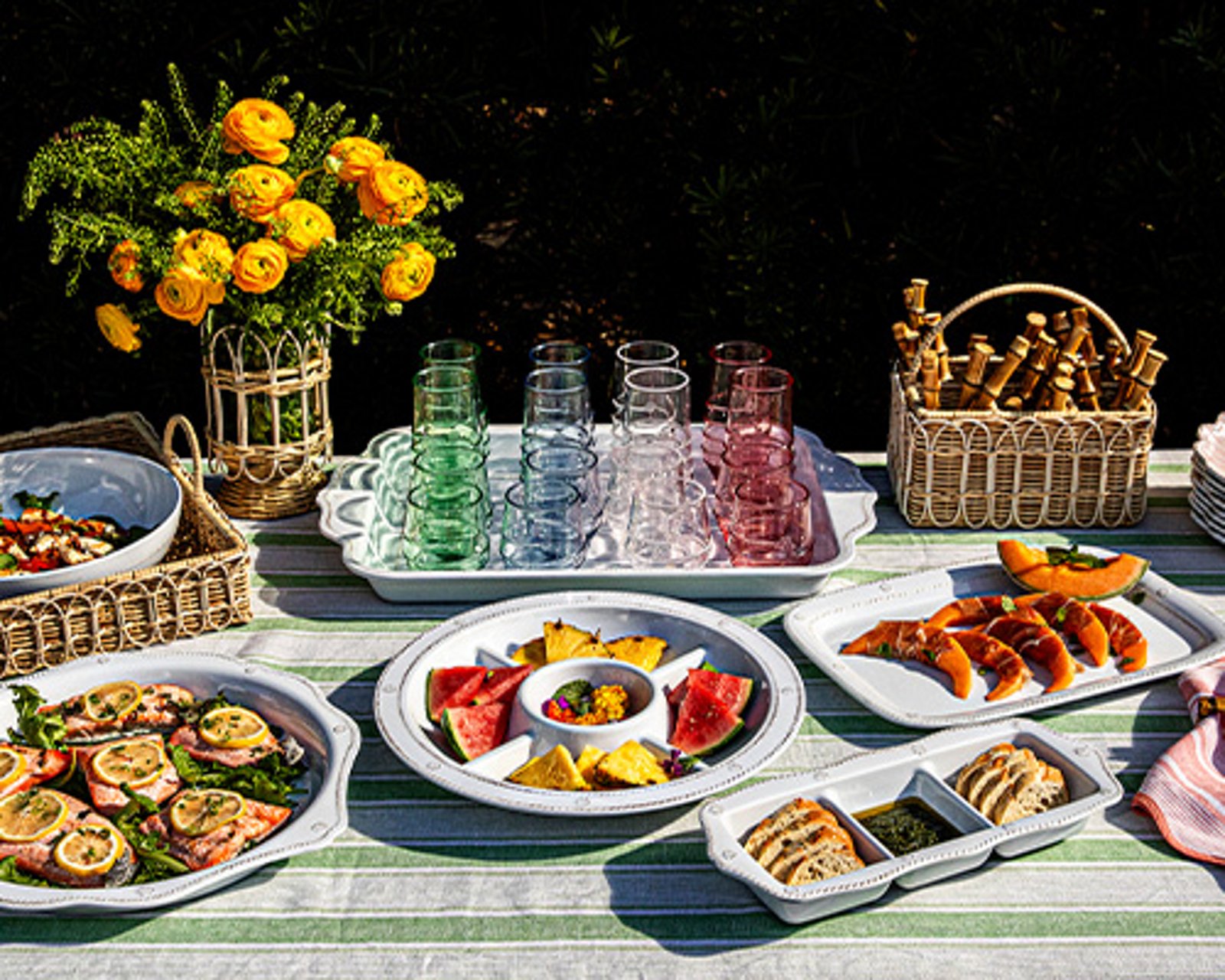 1 photo of Juliska table setting with circular serveware platters and rectangular serveware platters, featuring foods for a spring banquet.